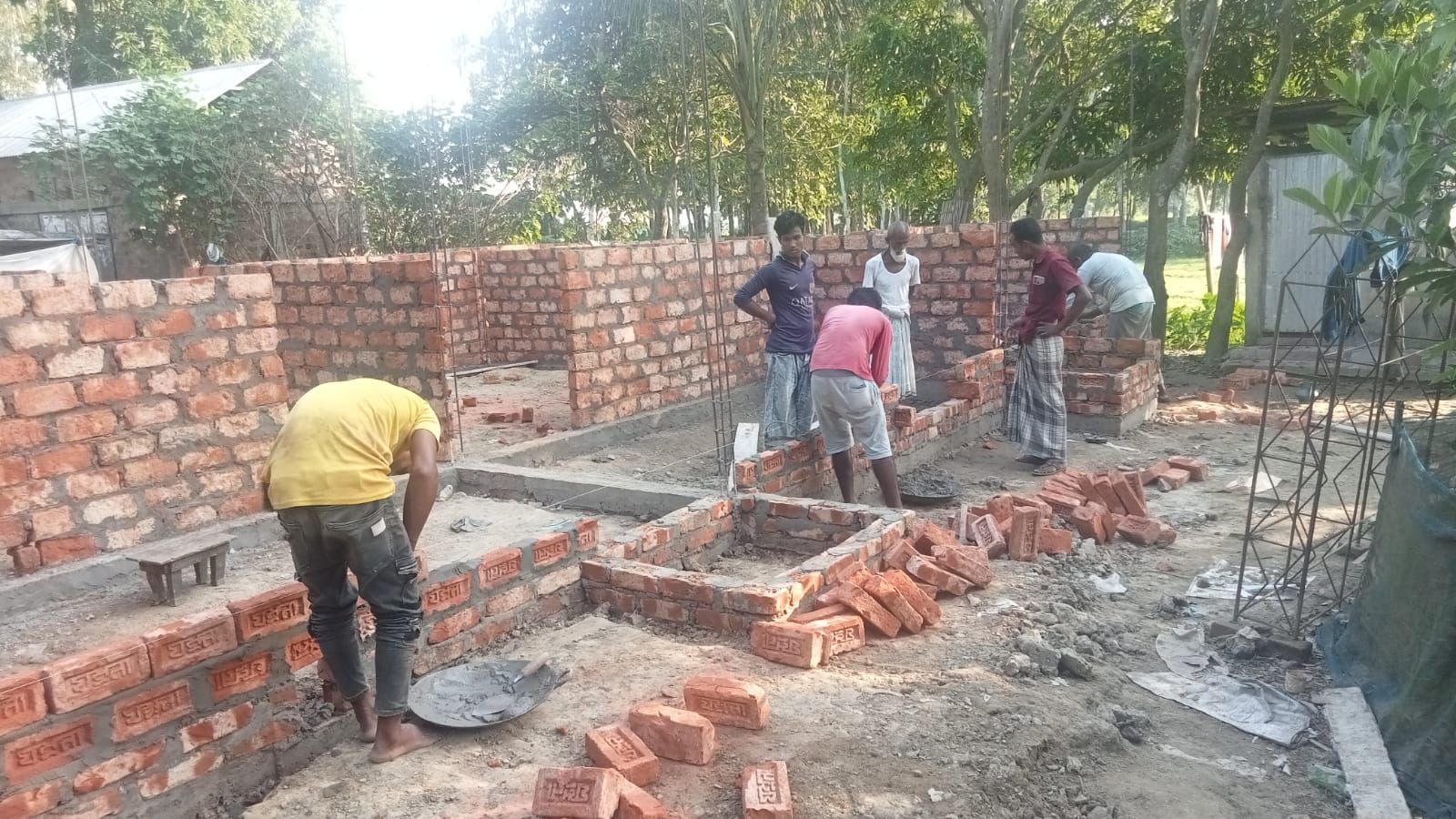 Workers constructing a new brick home for a family in Bangladesh